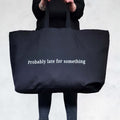 extra large black canvas tote bag with a custom text 'Probably late for something'