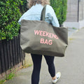 oversized olive green tote bag with a pale pink text 'Weekend Bag'