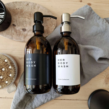 White and black waterproof labels on amber refillable shampoo bottles. The labels says his and her body wash.