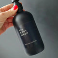Black personalised label sticker on a matte black bottle bottle with a main text HIS BODY WASH and a bottom text Bathroom Collection. All text can be personalised.