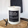Candle with a humorous label on a wooden surface