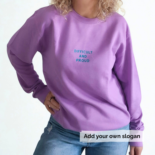 Person wearing a purple sweatshirt with 'DIFFICULT AND PROUD' text on a white background