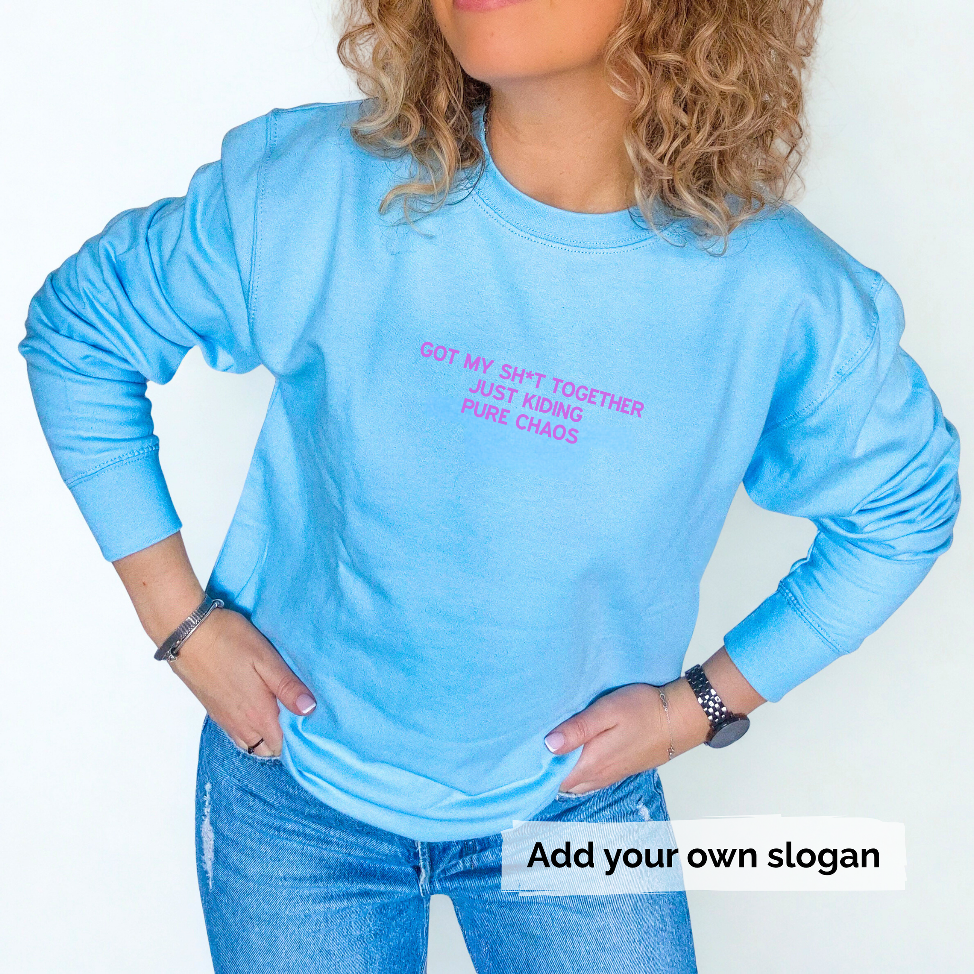 Person wearing a blue long-sleeve sweatshirt with text 'Got my shit together just kidding pure chaos' , standing against a plain background.