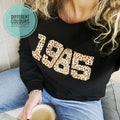 a woman wearing a Personalised Year Sweatshirt 1985 with Personalised Initials.