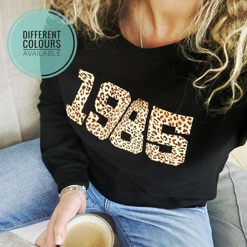 a woman wearing a Personalised Year Sweatshirt 1985 with Personalised Initials.