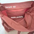 Brown bag with a secure zip and inside pockets on a white background