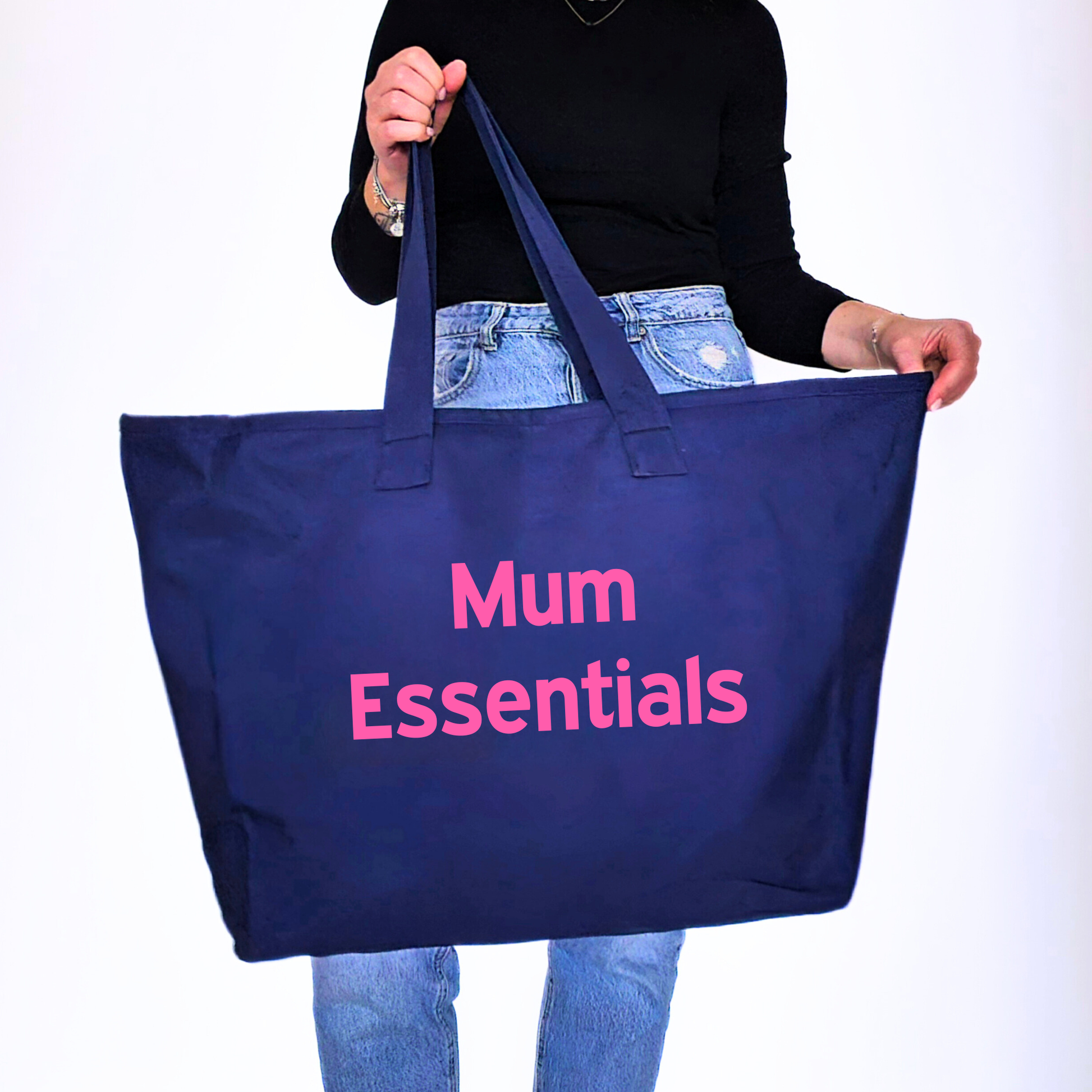Person holding a blue tote bag with 'Mum Essentials' text on a white background