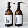 Two brown glass bottles with pump dispensers labeled 'Washing Up Liquid' and 'Hand Wash' on a light background.