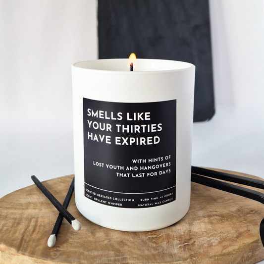 Candle with a humorous label on a wooden surface