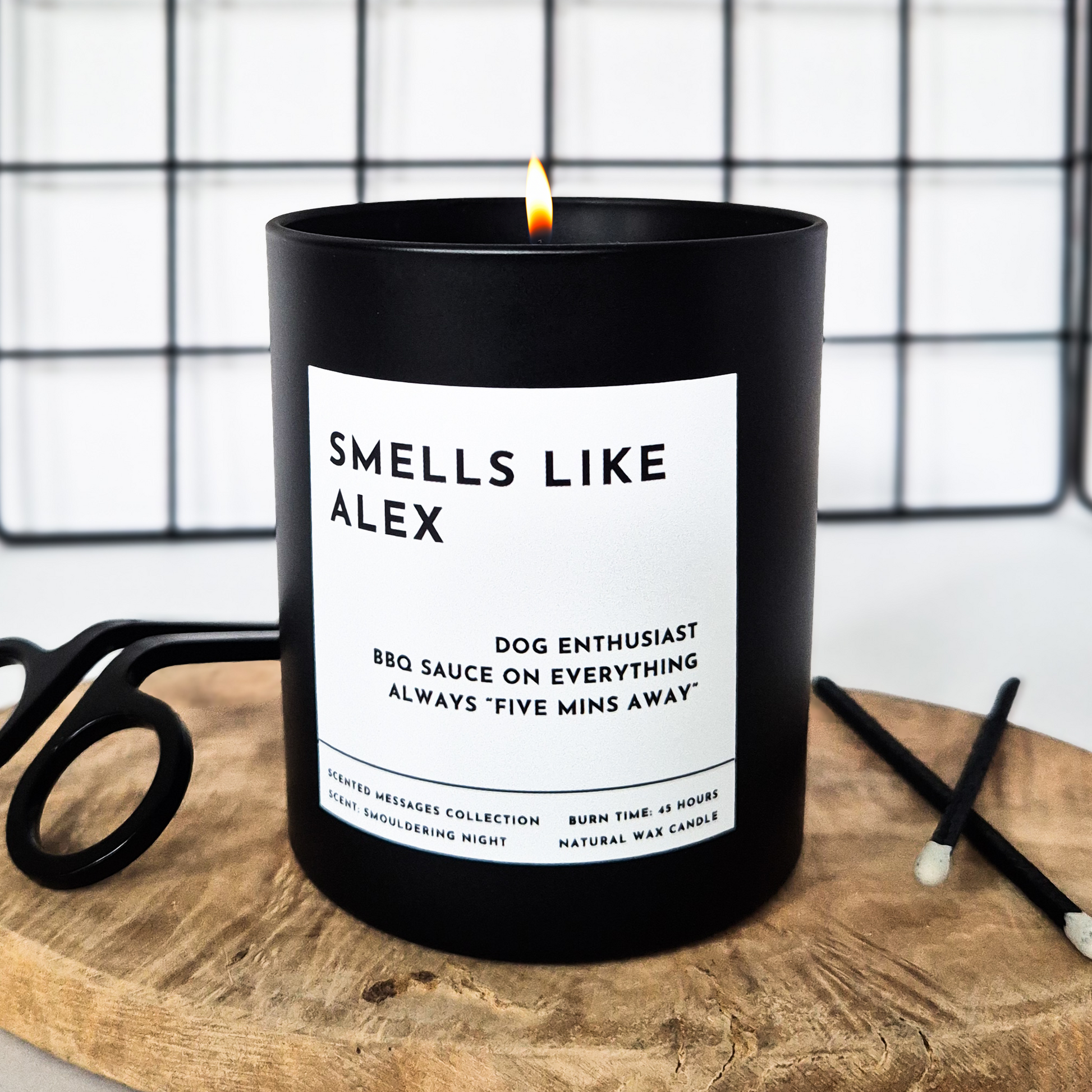 Black candle with custom name and a personalised, funny message on a wooden tray