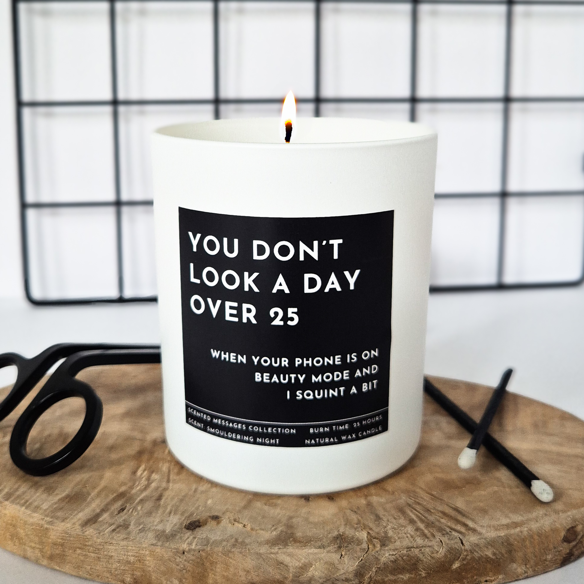 Candle with a humorous label on a wooden surface