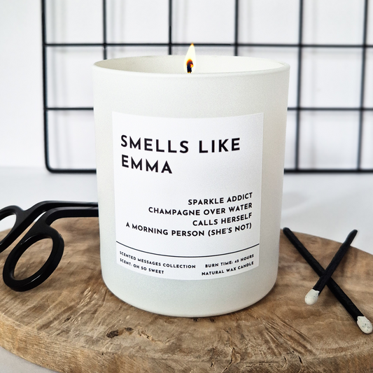 White candle with personalised name and a funny message underneath on a wooden tray