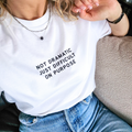 Person wearing a white t-shirt with text 'NOT DRAMATIC JUST DIFFICULT ON PURPOSE' sitting on a couch.
