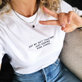 Person wearing a white t-shirt with text 'Got my shit together just kidding pure chaos' and making a peace sign.
