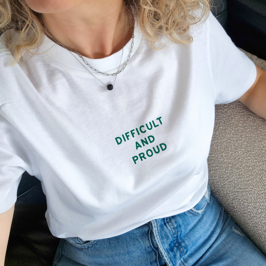 Person wearing a white t-shirt with 'DIFFICULT AND PROUD' text in green.
