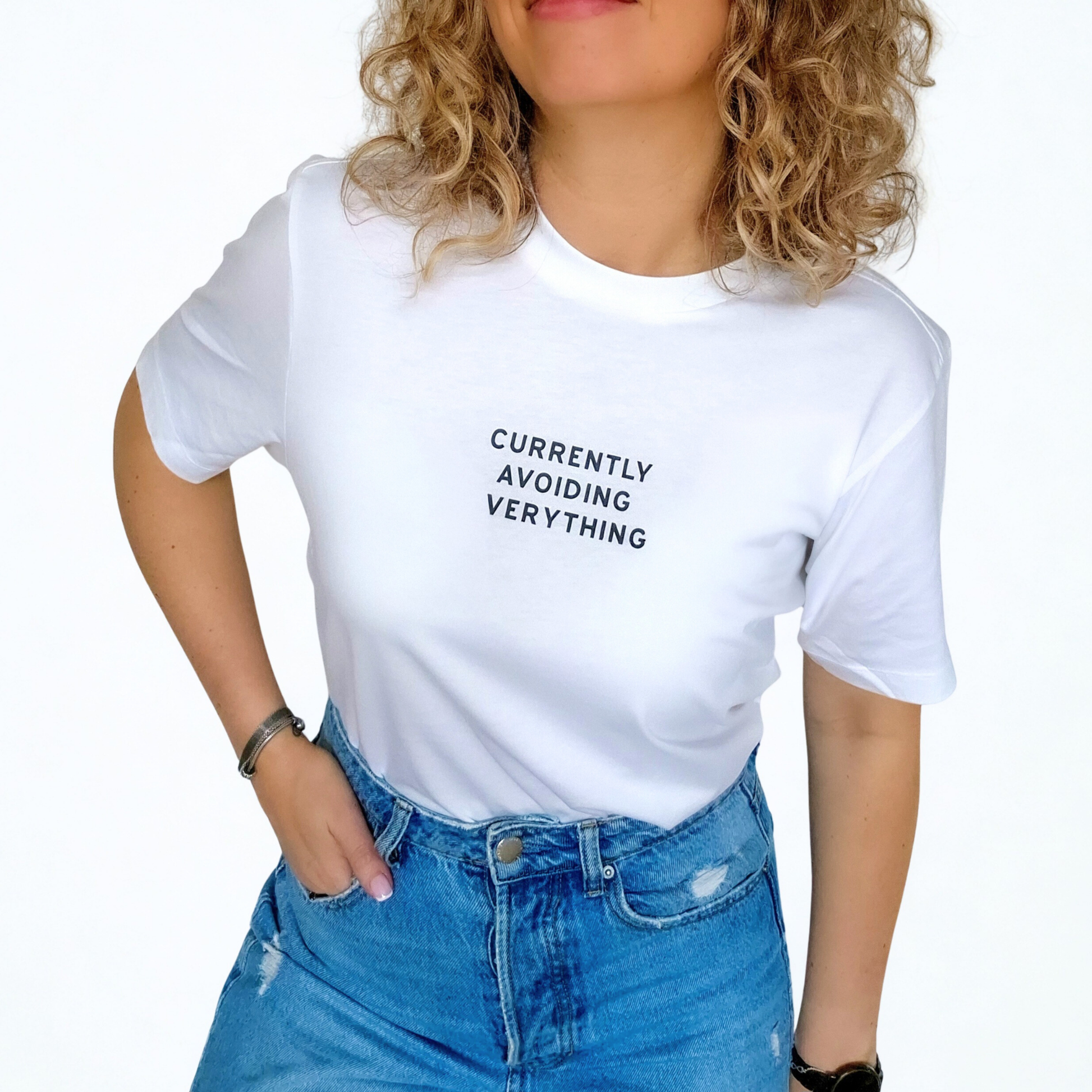Person wearing a white t-shirt with text 'Currently voiding everything' and blue jeans on a white background