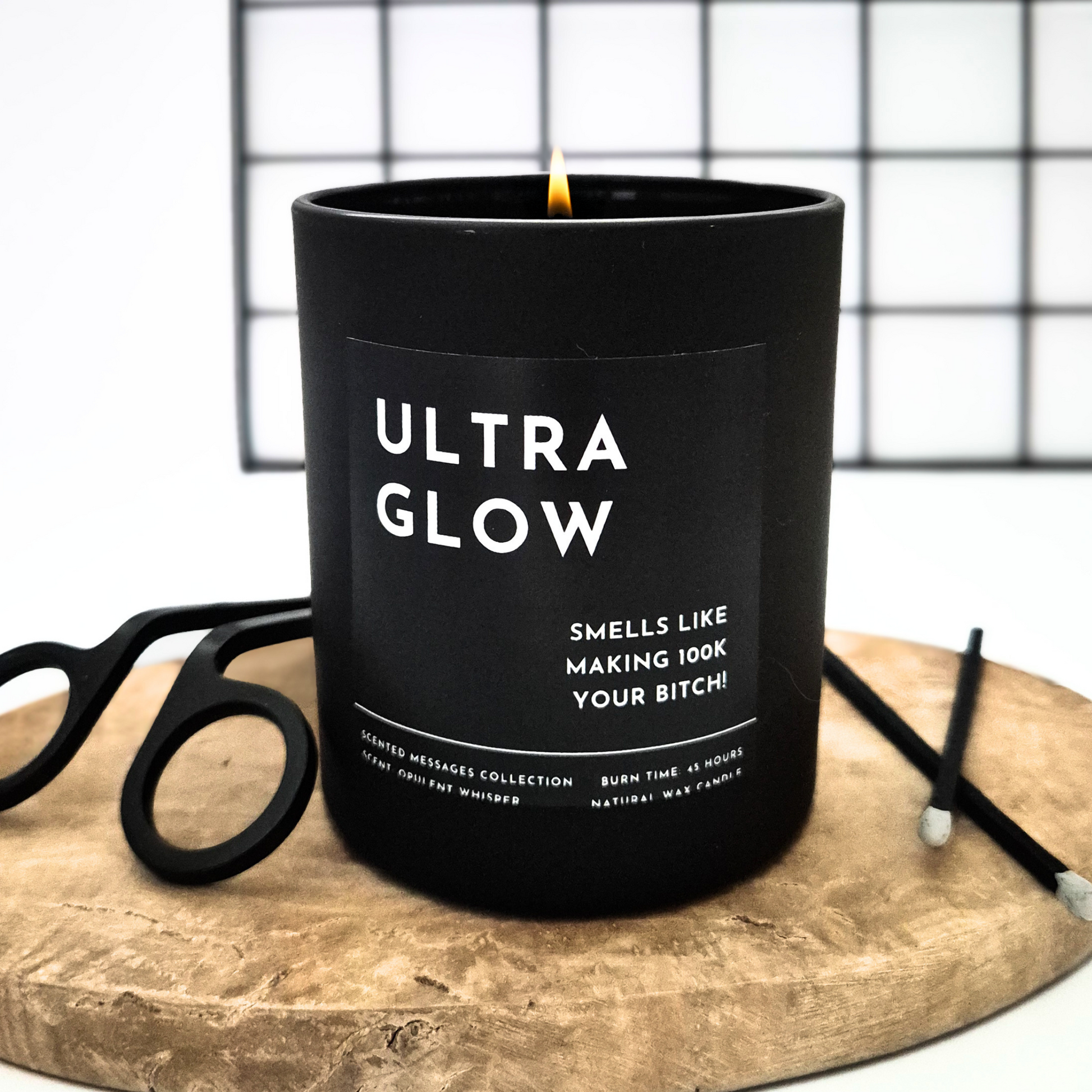 Black candle labelled 'Ultra Glow' with personalised message on a wooden surface.