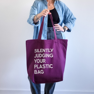 Plum large personalised canvas tote bag with cream text reading Silently Judging Your Plastic Bag, shoulder carry, printed in our London studio