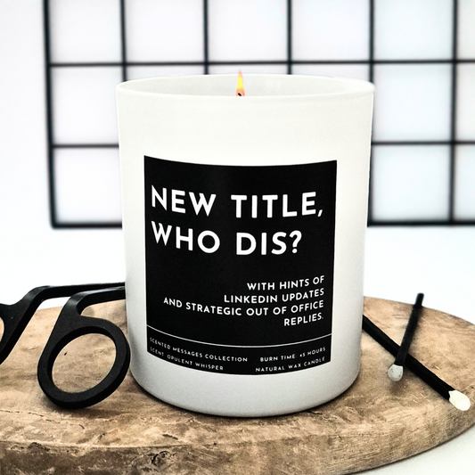 Candle with a humorous new job, promotion label on a wooden surface.