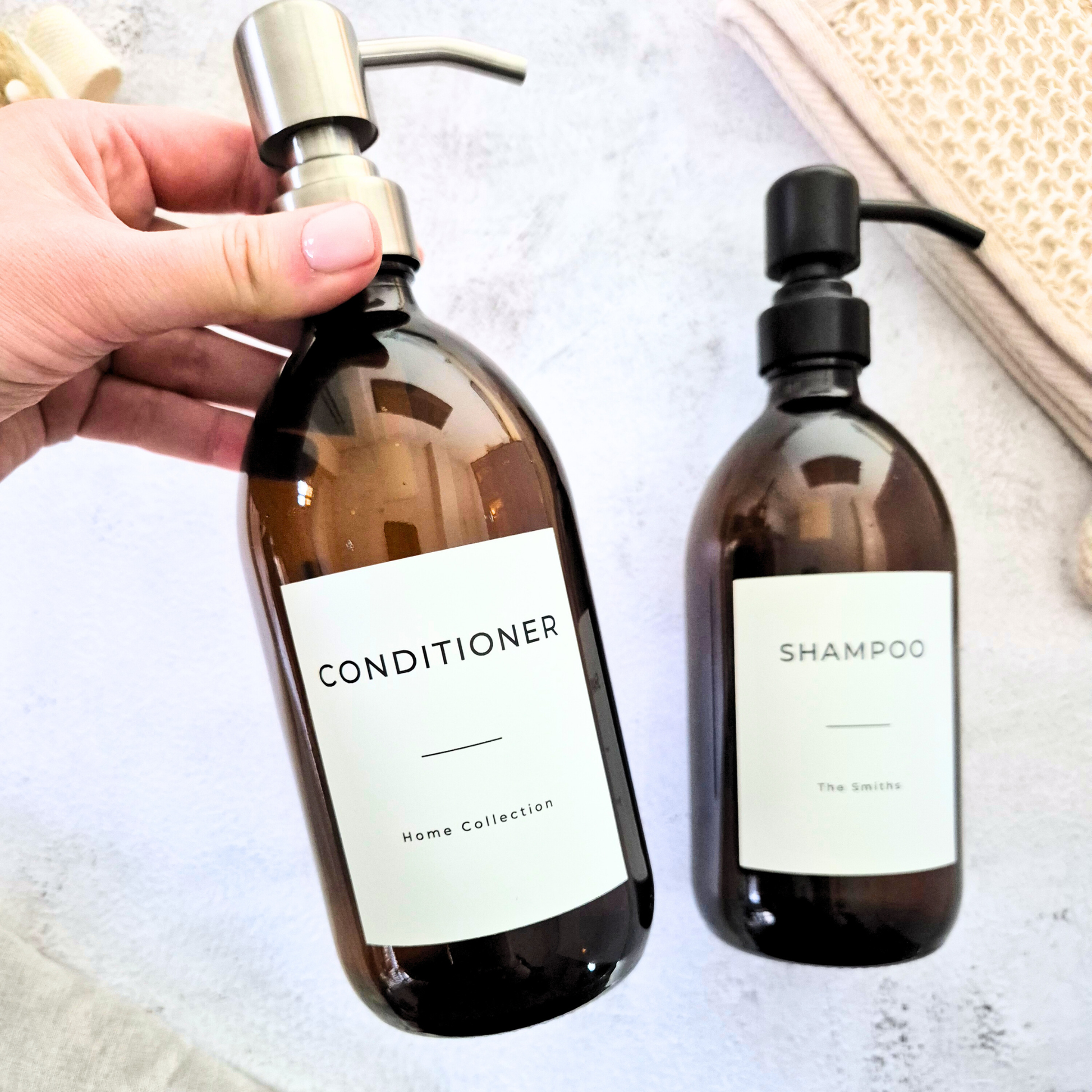 Two brown bottles labeled 'Conditioner' and 'Shampoo' on a light surface.