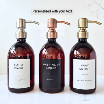 Three bottles of hand wash, washing up liquid, and hand lotion with pump dispensers on a white background.