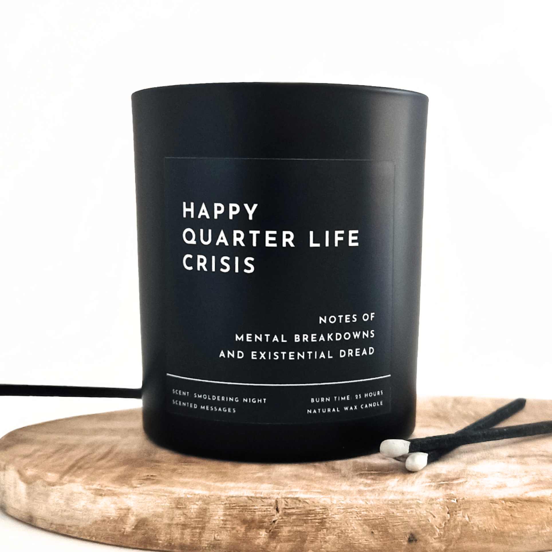 A back candle with personalised text 'Happy Quarter Life Crisis' on a wooden board. 
