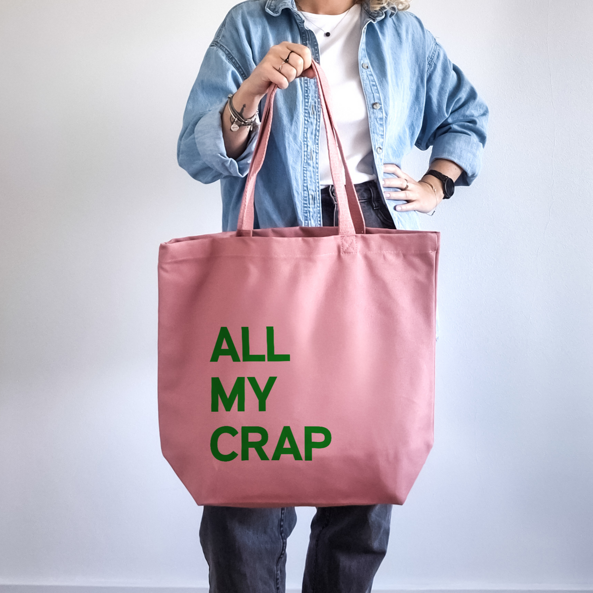 Pink large personalised canvas tote bag with dark green text reading All My Crap, front-facing both handles, printed in our London studio
