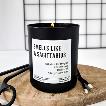 Black candle with a label on a wooden board against a grid background