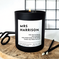 Black candle with a personalised label on a wooden surface. Text in bold 'Mrs Harrison' - a personalised teacher's name, and a personalised message underneath 'for the patience, the kindness and everything in between. Thank you from Natalie. 